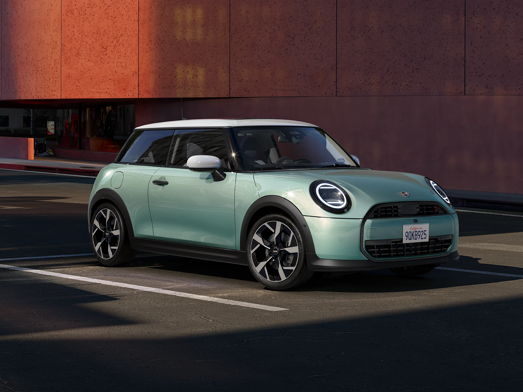 MINI Cooper 3 Kapı'nın Ocean Wave Yeşili ve Beyaz Çatı renklerinde yandan ön görünümü.