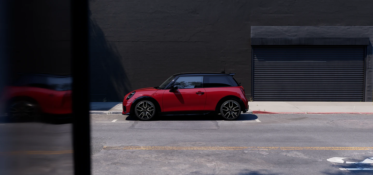 Chili Red ve Black Roof park yerindeki MINI Cooper'ın yandan görünümü.