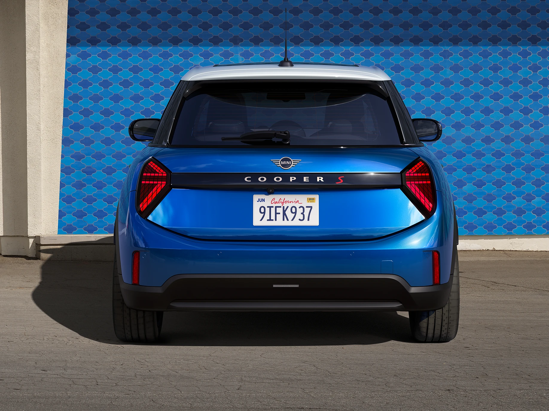 MINI Cooper 5-Door'un Icy Sunshine Blue ve Multitone Roof Blue renklerinde arkadan görünümü.
