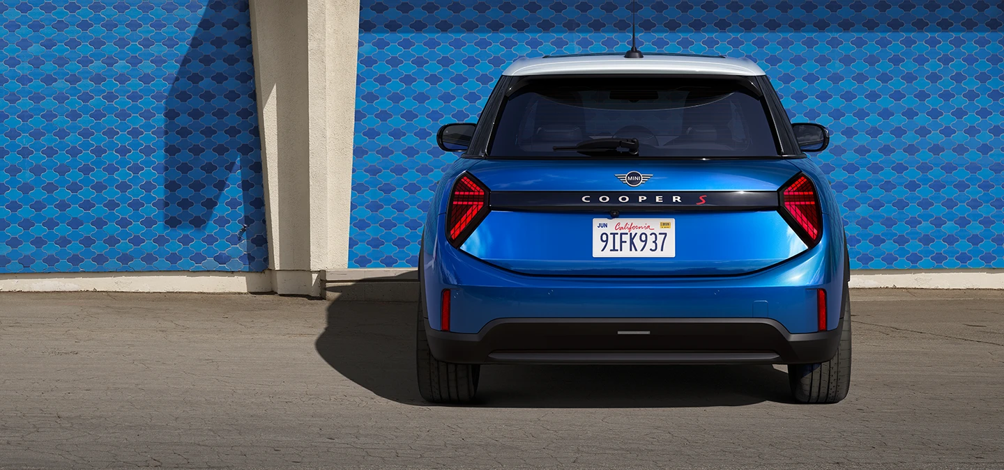 MINI Cooper 5-Door'un Icy Sunshine Blue ve Multitone Roof Blue renklerinde arkadan görünümü.
