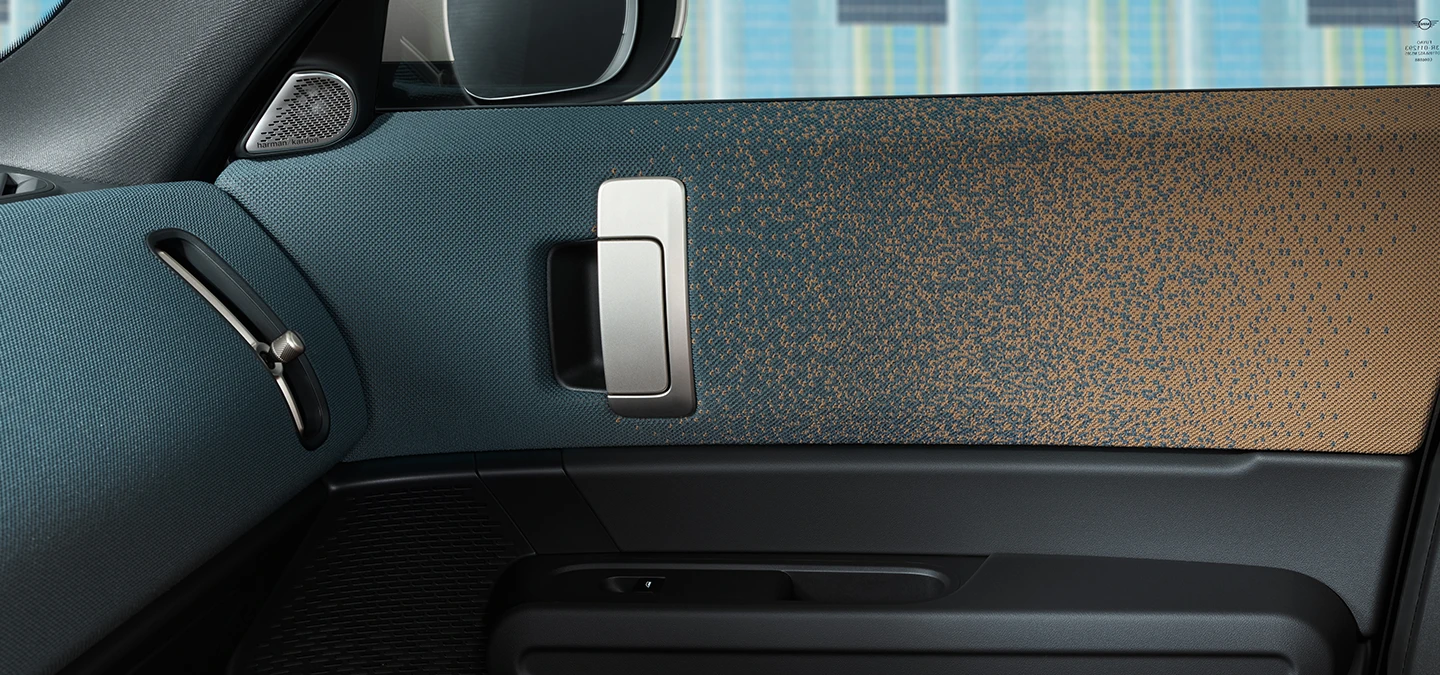 Tamamen Elektrikli MINI Countryman'ın iç tasarımının kapıya ve gösterge paneline odaklanarak yakından görünümü.