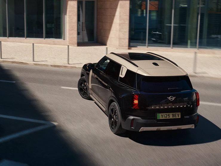 Tam elektrikli MINI Countryman'ın Midnight Black renkli Vibrant Silver Roof park yeri ile arkadan görünümü,