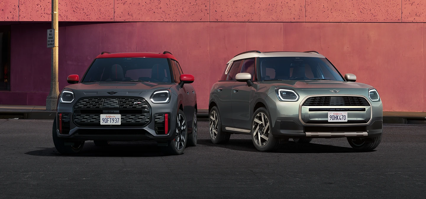 MINI Countryman JCW'nin Legend Grey ve Red Roof ile yan yana duran Smokey Green ve Vibrant Silver Roof modellerinin önden görünümü.