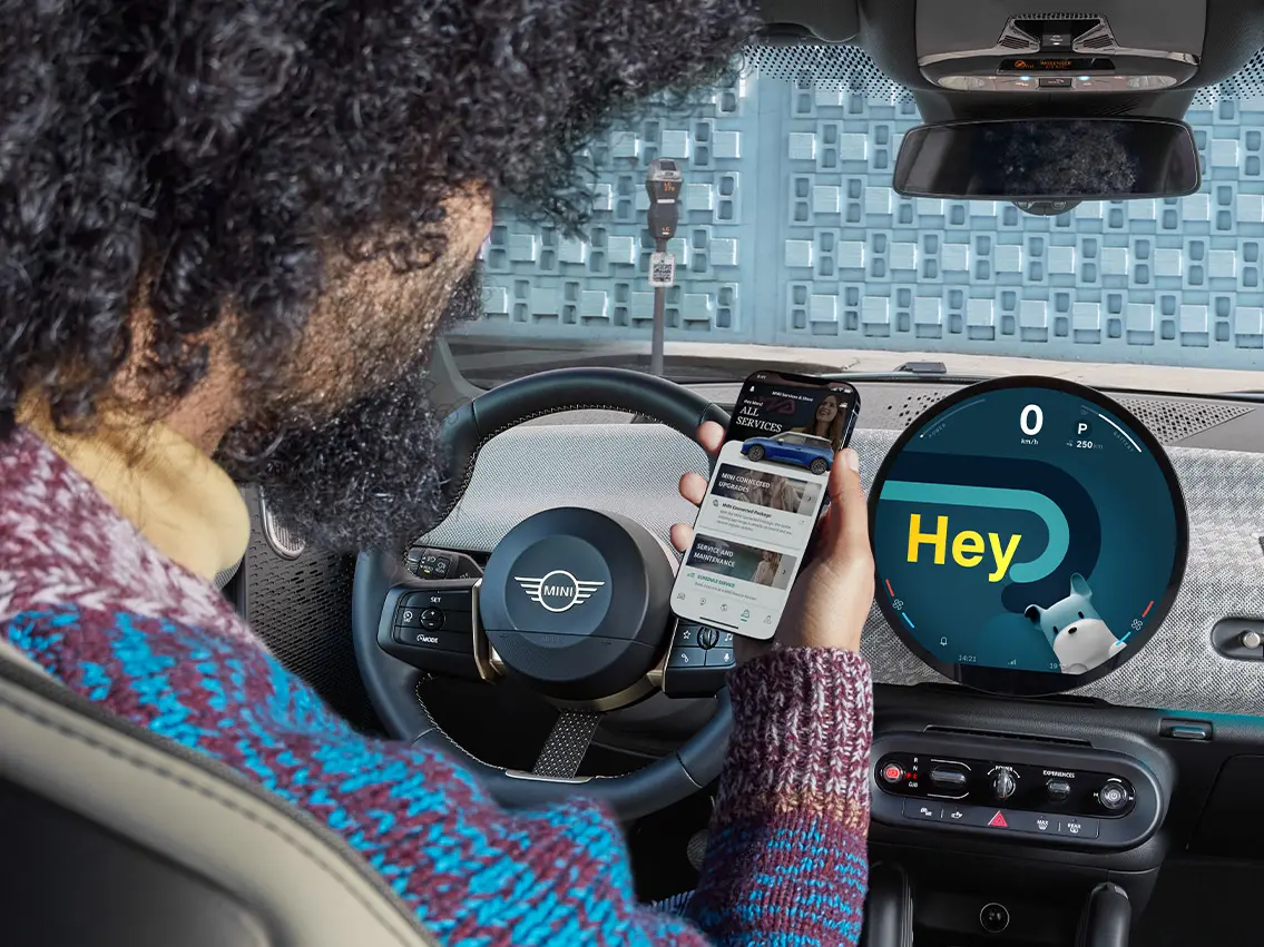 MINI'de oturan bir adam telefonuna bakıyor