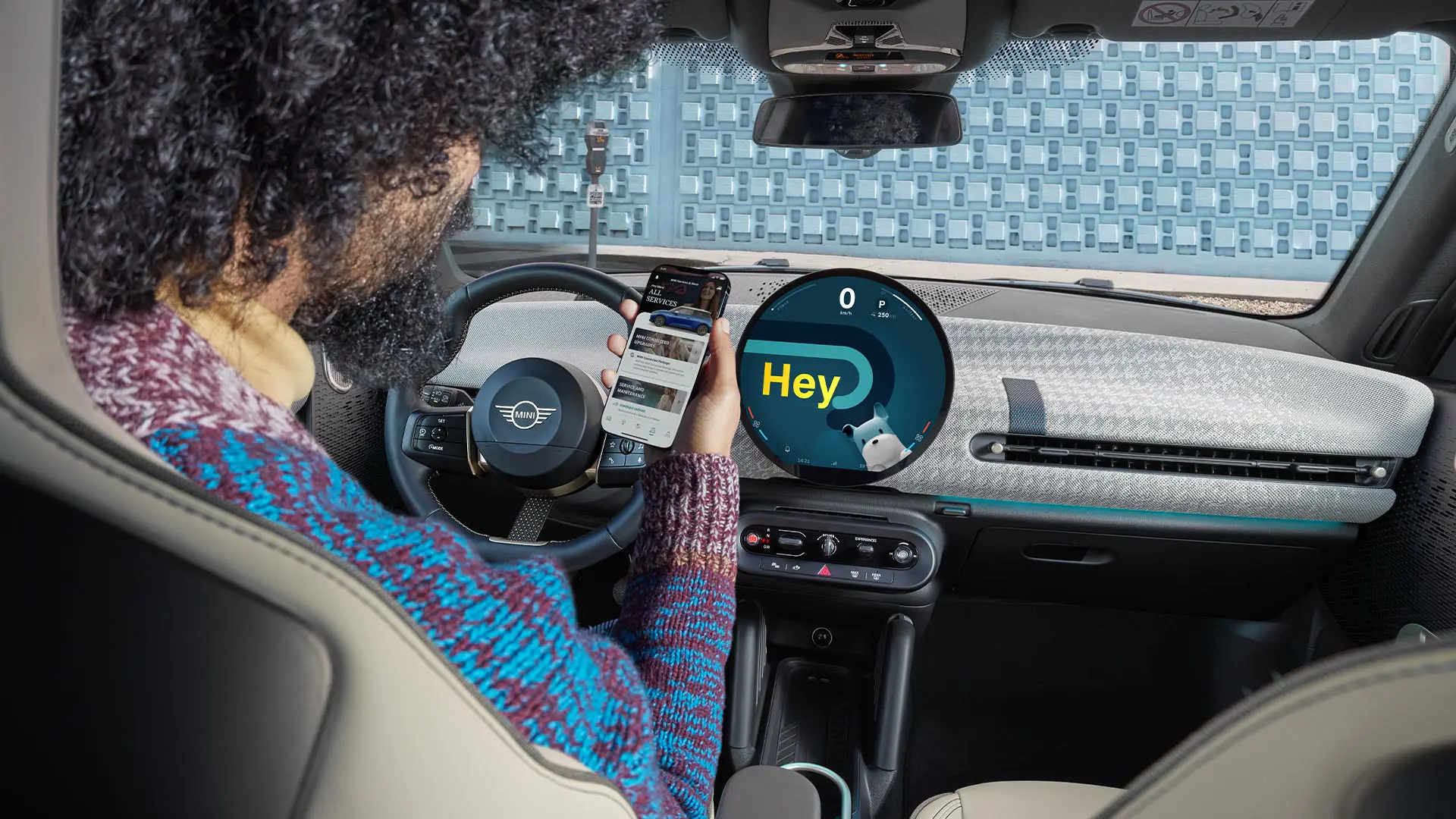 MINI'de oturan bir adam telefonuna bakıyor