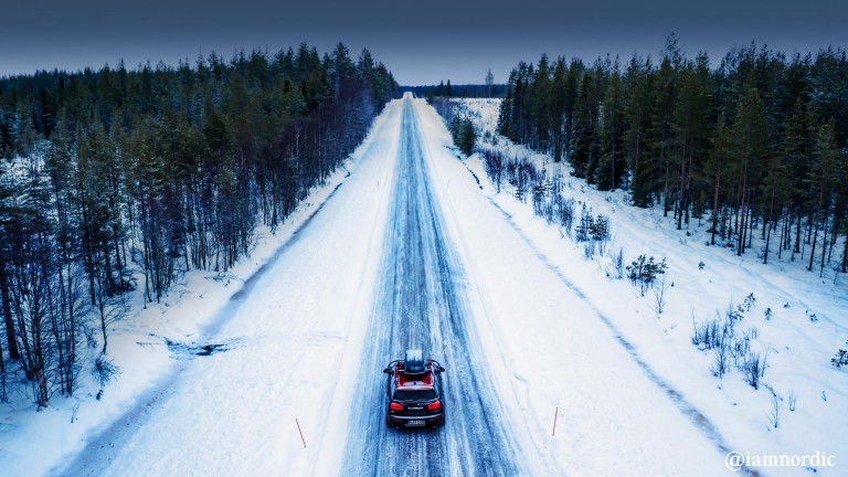 Portbagaj takılı MINI Cooper’ın karlı bir yol üzerinde arkadan görüntüsü