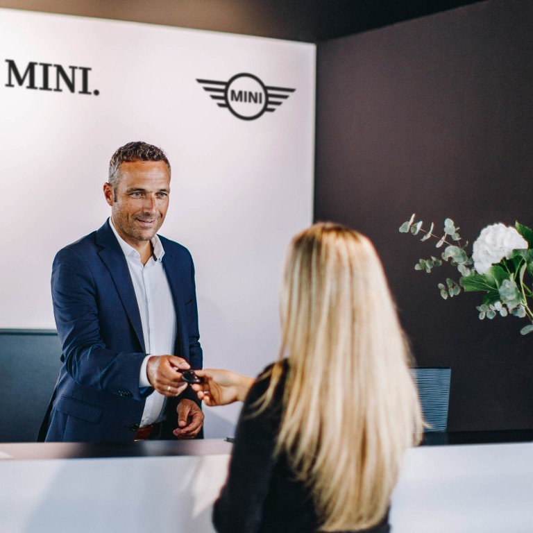 MINI Aksesuarları - otomobil anahtarını bir kadına teslim eden mini yetkili servis temsilcisi